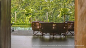A view of a wooden deck with wicker furniture and a pool, overlooking a lush tropical garden. - KClub Ubud (Tegallalang)