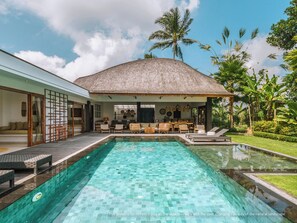 A modern house with a swimming pool, outdoor seating, and tropical vegetation. - KClub Ubud (Tegallalang)