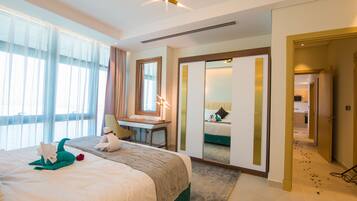 A hotel room with a large bed, a desk, a mirror, and a view of the bathroom.
