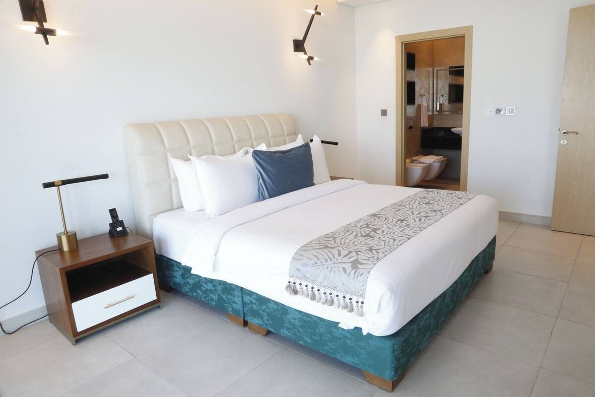 A modern bedroom with a bed, bedside table, and a wardrobe.