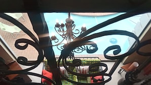 Un garde-corps de balcon en fer forgé offrant une vue sur une cour et un bâtiment en arrière-plan.