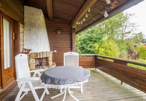Enjoy dining or socializing on the deck with a stone fireplace and comfortable seating.