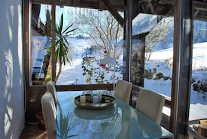 Enjoy a meal with a view of the snowy landscape from this cozy dining area.