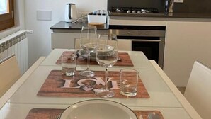 A dining area with a table set for four, including plates, cutlery, and glasses. - Ca' Berto Apartment (Venezia)