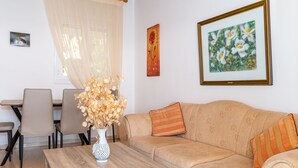 A living room with a sofa, a coffee table, and a dining area with chairs and a table. - Villa Katina - private pool & sea view (Corfu)