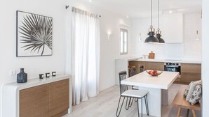Una cucina moderna con isola centrale, illuminazione a sospensione e zona pranzo con sedie.