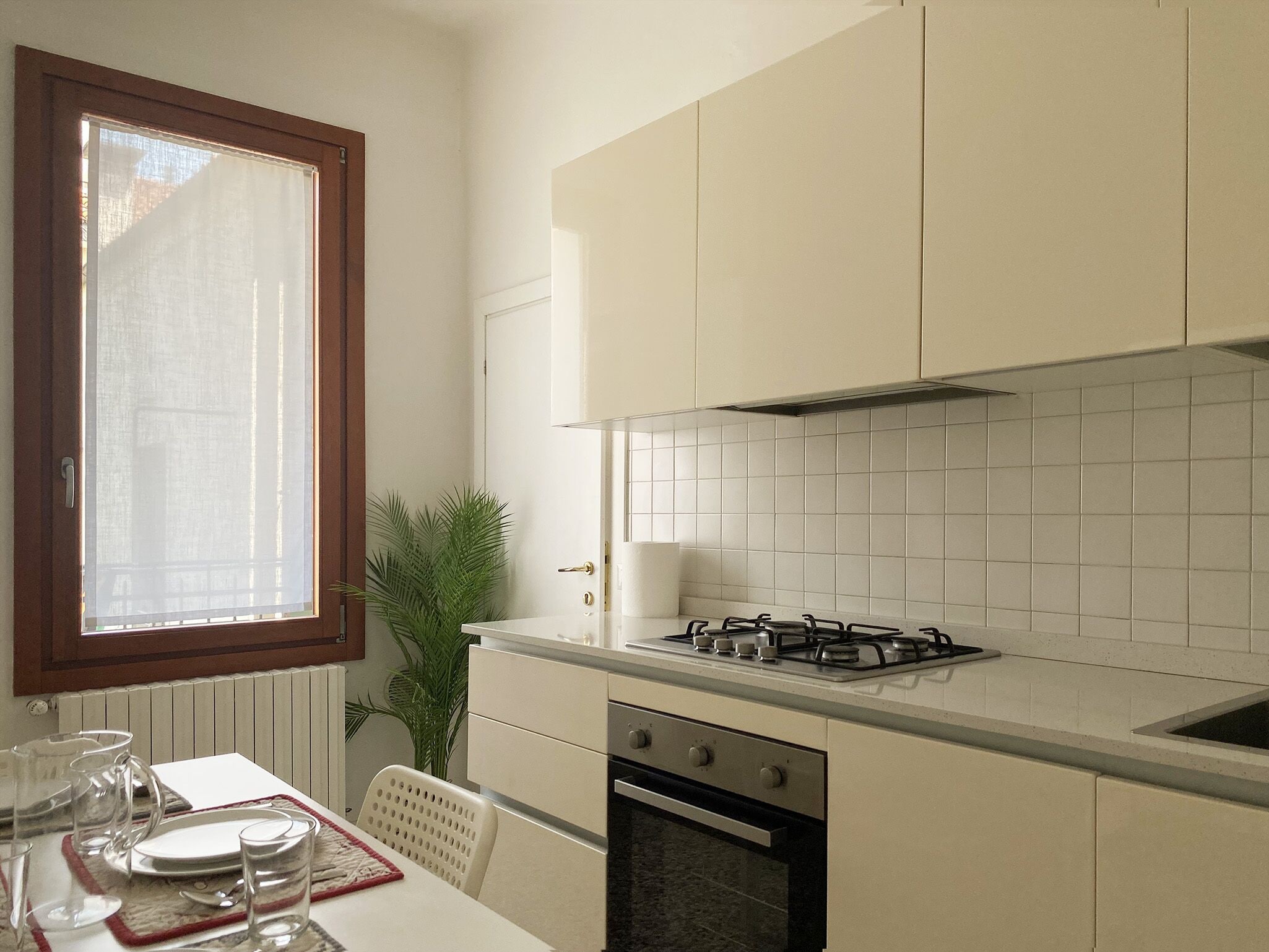A compact kitchen with a gas stove, oven, and white cabinets.