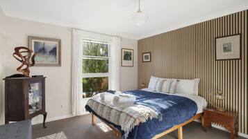 2 habitaciones, escritorio y tabla de planchar con plancha