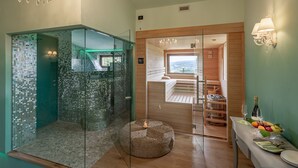 A modern bathroom with a glass-enclosed shower, a wooden bench, and a breakfast setup with fruit and wine. - Podere Val D'Orcia - Tuscany Equestrian (Sarteano)
