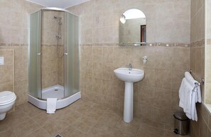 A bathroom with a glass-enclosed shower, a pedestal sink, and a toilet. - Hotel Hanul Domnesc (Sacele)