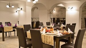 Un restaurant doté de nombreuses tables, chacune étant agrémentée de chaises et recouverte d’une nappe.