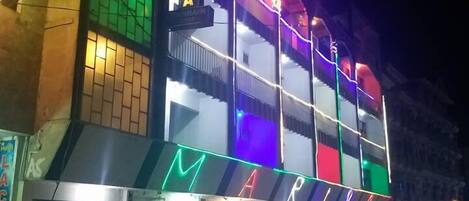 Hotel Marina offers a vibrant and modern appearance with a prominent entrance and glass door.
