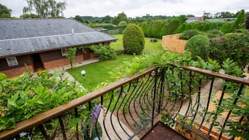 Il s’agit d’une propriété résidentielle comprenant une maison en briques, un jardin avec différentes espèces de plantes et une clôture en bois.
