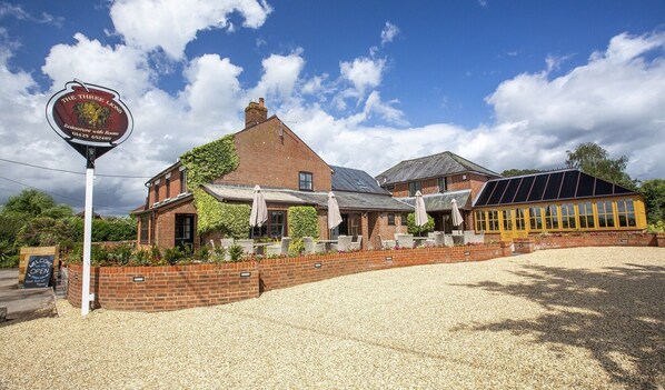 A brick building with a sign for 'The Three Lions Restaurant with Rooms'. - The Three Lions (Fordingbridge)