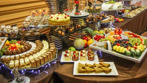Un buffet proposant une variété de desserts, de fruits et d’en-cas.