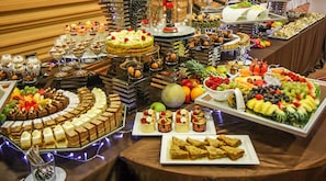 Un buffet proposant une variété de desserts, de fruits et d’en-cas.