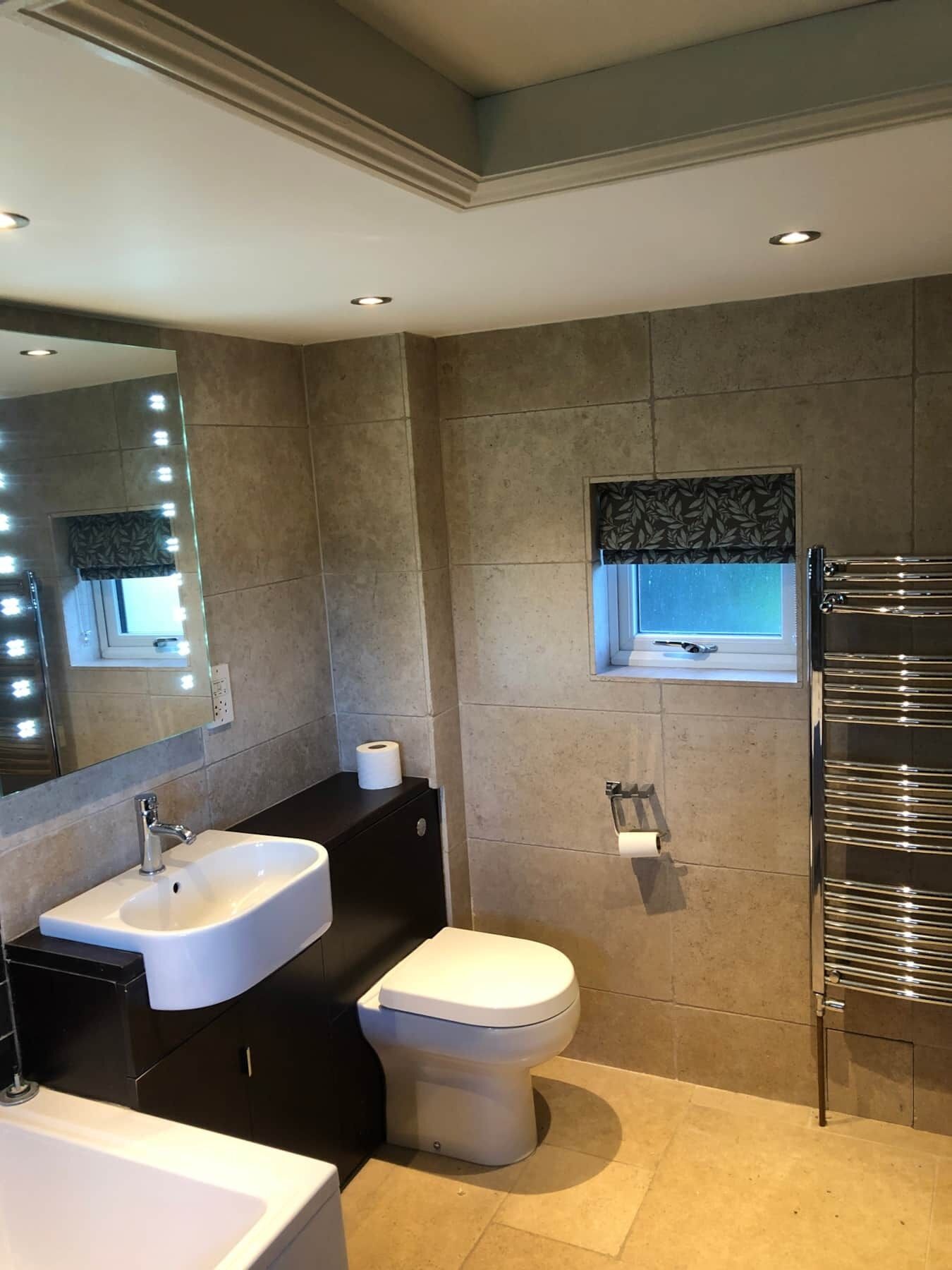 Un bagno moderno con lavandino, water e porta asciugamani.