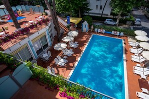 A rooftop pool area with sun loungers, a slide, and a small play structure. - Hotel Villa dei Fiori (Rimini)
