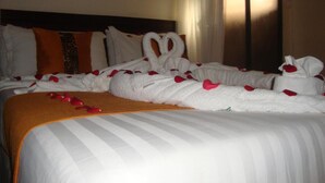 A hotel room with a neatly made bed, a headboard, and a framed picture on the wall. - GraceHouse Resort (Nairobi)