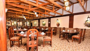 A restaurant with wooden beams and tiled flooring, featuring multiple tables and chairs. - GraceHouse Resort (Nairobi)