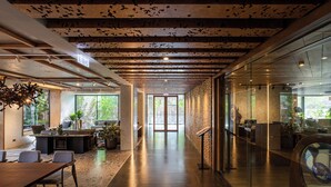 A modern office space with a long corridor, glass walls, and a wooden ceiling. - Gardina Asoke Hotel & Residence (Bangkok)