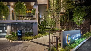 A modern building with a sign for "Cafarnaú" and a parking area with a sign for "Lobby Parking". - Gardina Asoke Hotel & Residence (Bangkok)
