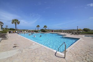 Relax by the pool surrounded by lounge chairs and umbrellas.