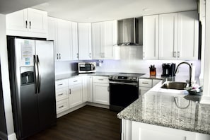 Enjoy cooking in this well-equipped kitchen with a refrigerator, microwave, oven, and sink.