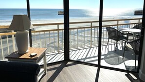 A balcony with a view of the beach, a lamp, and a table with chairs. - Oceanfront! - All New! Ultra Modern Farmhouse Chic at the Beach! (Myrtle Beach)