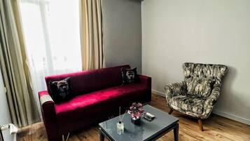 Suite Deluxe | Área de sala de estar | Televisión LCD de 106 cm con canales vía satélite y televisión