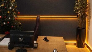 A modern room with a wooden desk, a computer, a Christmas tree, and a sign that reads "ZEBRA HOME". - Zebra Hotel Alsancak (Izmir)