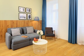 Suíte, 1 quarto, sacada | Área de estar | Smart TV 55 polegadas com canais via satélite