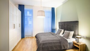 A bedroom with a bed, bedside table, and wardrobe. - Jimmy's Apartments Dandelion (Vienna)