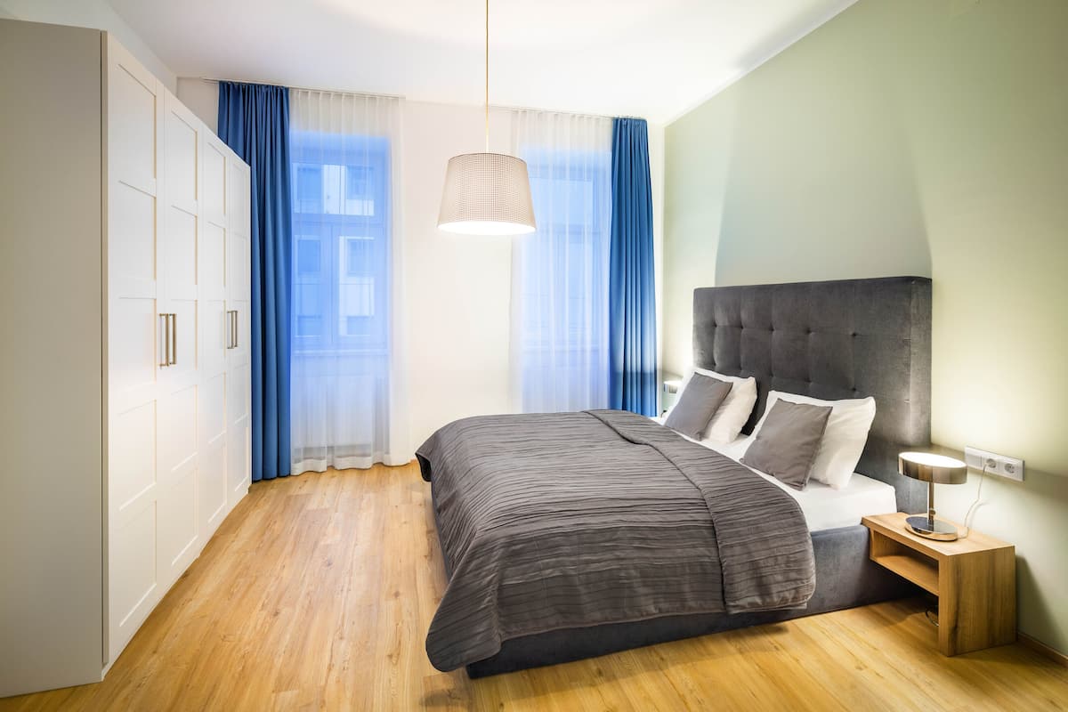 A bedroom with a bed, bedside table, and wardrobe.