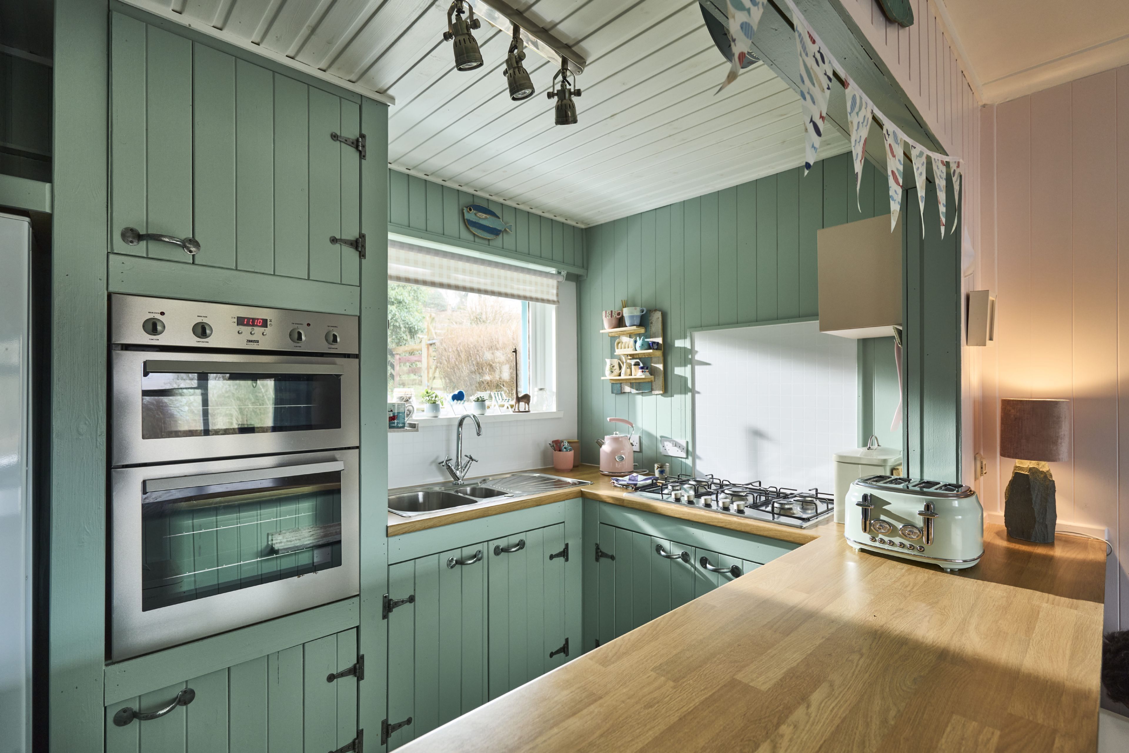 A kitchen with teal cabinets, a wooden countertop, a gas stove, and a built-in oven. - The Moorings, overlooking Loch Fyne - sleeps 4 guests  in 2 bedrooms (Cairndow)