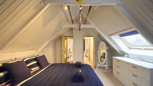 A bedroom with a large bed, a wardrobe, a mirror, and a skylight. - The Moorings, overlooking Loch Fyne - sleeps 4 guests  in 2 bedrooms (Cairndow)