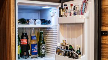 Un refrigerador abierto repleto de diversas bebidas, incluyendo botellas de Coca-Cola, Matzá y Heineken.
