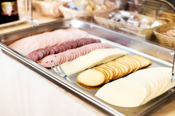 Una vitrina con diversos alimentos, incluyendo pan en rebanadas y pastelería.