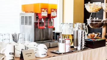 A coffee station with a coffee machine, coffee cups, a milk pitcher, and a coffee grinder.