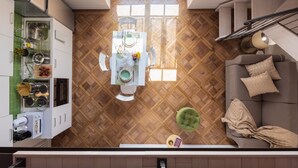 Een moderne keuken met een eethoek, houten vloeren en een trap naar een hoger gelegen verdieping.
