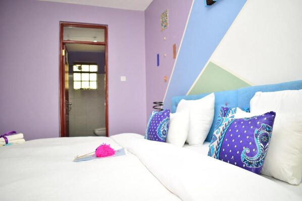 A bedroom with a bed, pillows, and a door leading to another room. - Cozy Room JKIA (Mlolongo)