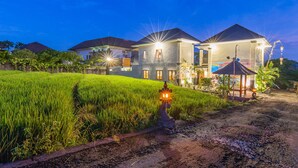 A modern house with a well-maintained garden and a pathway leading to the entrance. - Ayuna Suites Canggu By Zuzu (Tibubeneng)