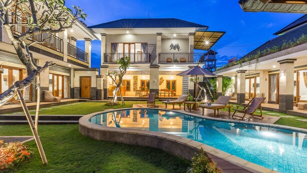A two-story building with a swimming pool, outdoor seating, and a well-maintained lawn. - Ayuna Suites Canggu By Zuzu (Tibubeneng)