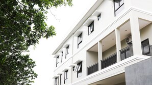 A multi-story building with balconies, large windows, and a flat facade.