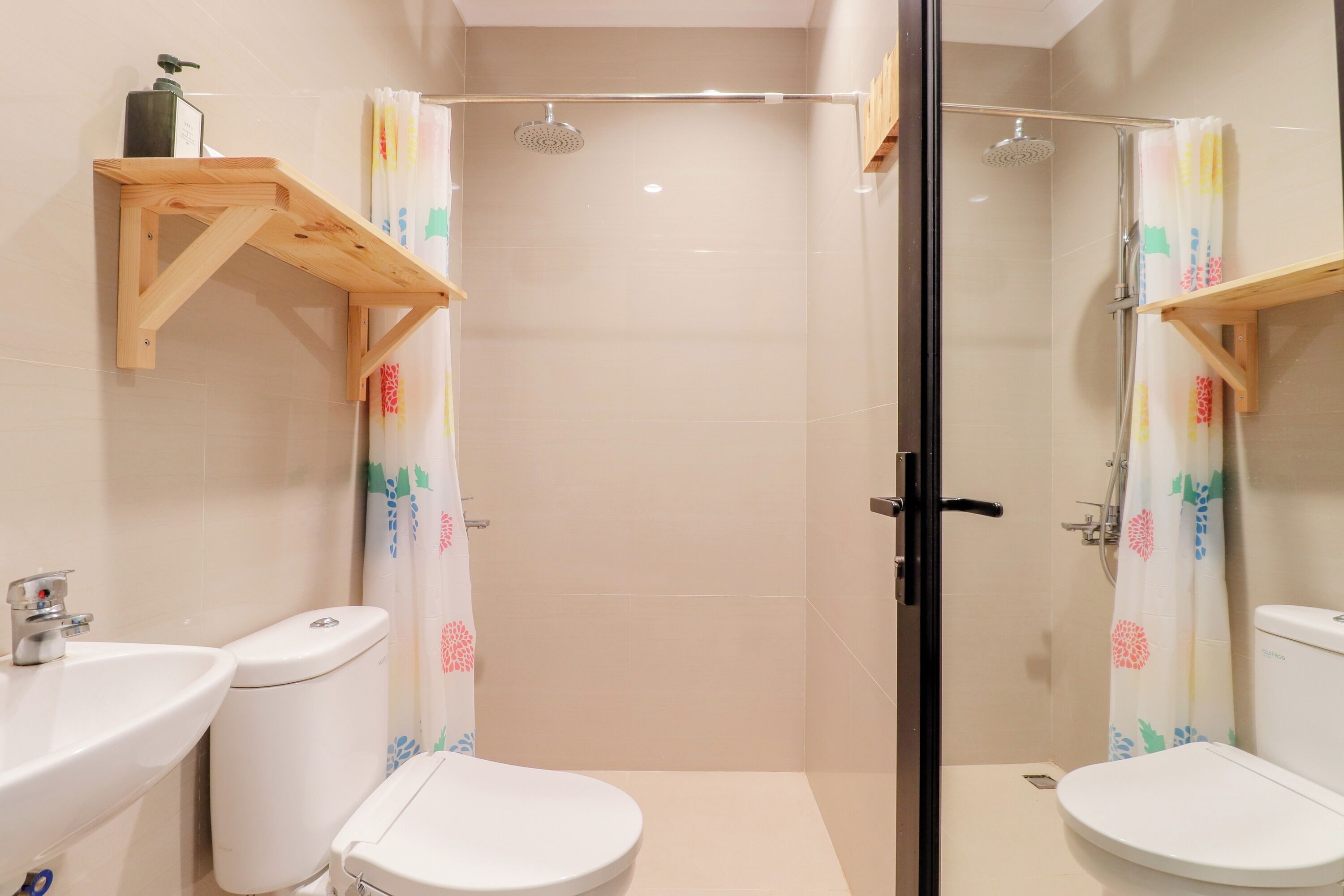 A bathroom with two toilets, a shower, and a sink.