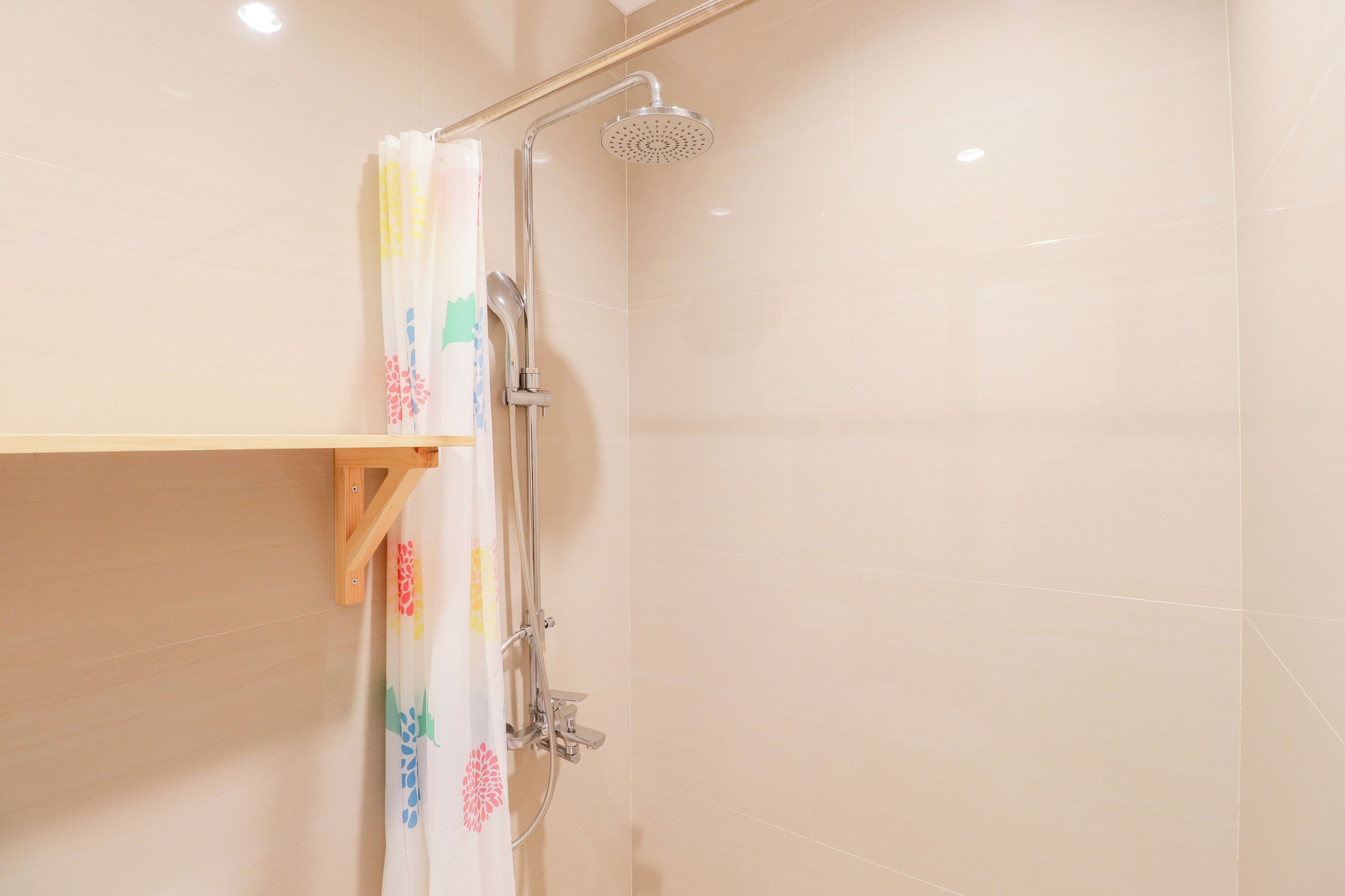 Une douche équipée d’un pommeau de douche à main et d’un robinet mural.