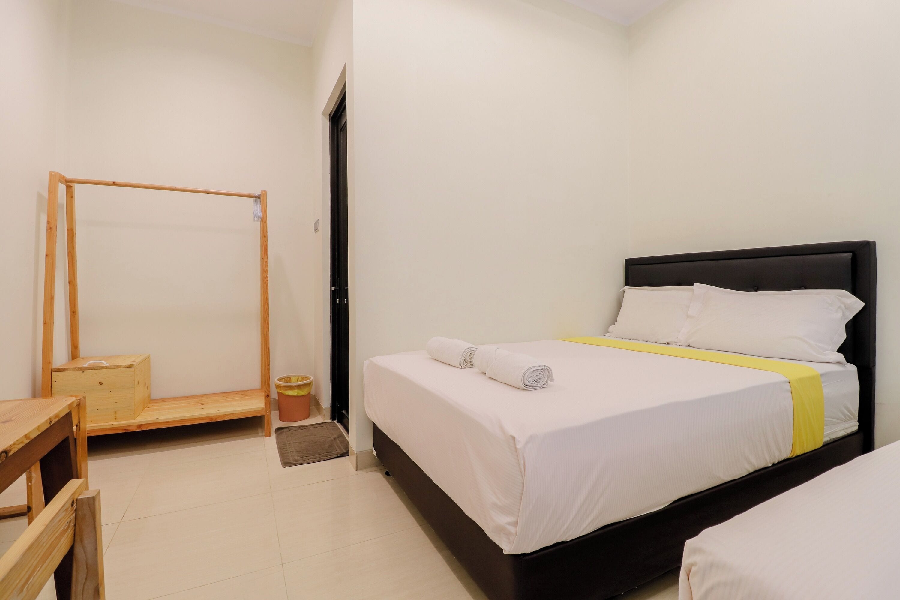 A bedroom with a bed, a wooden chair, and a small wooden table.