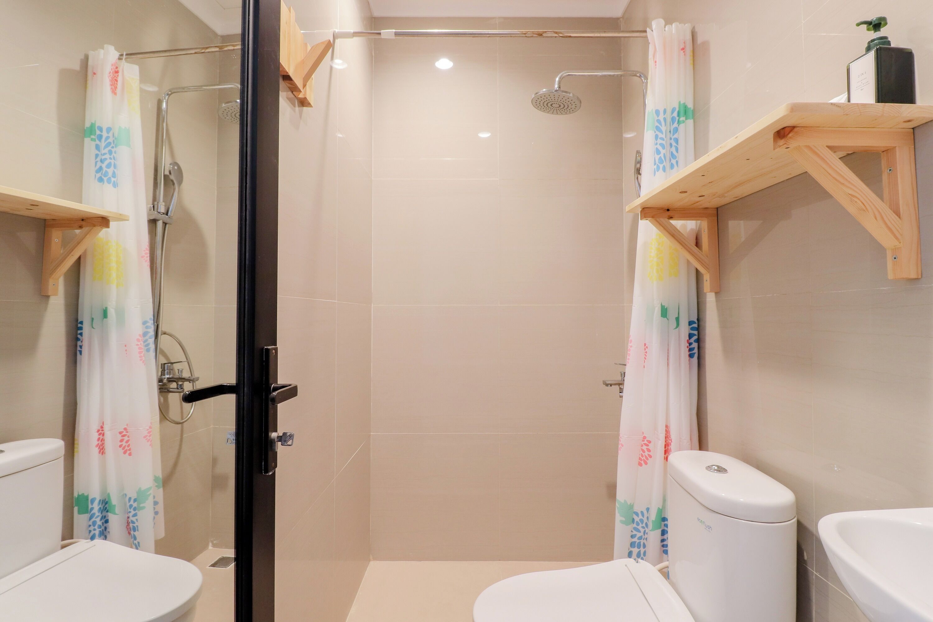A bathroom with a glass-enclosed shower, a toilet, and a sink.