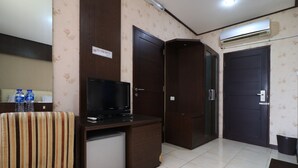 A hotel room with a television, a small refrigerator, a water dispenser, and a 'No Smoking' sign. - I Residence Bandung (Bandung)