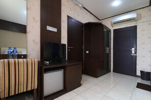 Relax in this cozy space with a television, refrigerator, and water dispenser, plus a comfortable bed for a restful stay.